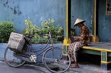 Woman sitting near her bicycle Yogyakarta Indonesia