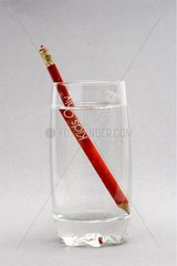 Red pencil in glass filled with water Studio