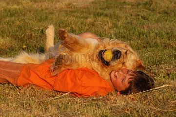 Enfant et golden retriever jouant dans l'herbe