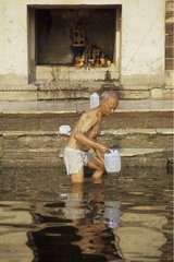 Homme prélevant de l'eau dans le Gange Inde