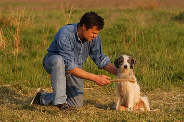 Homme donnant un os à son chien