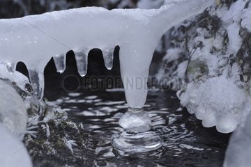 Stalactite ice on the frozen creek in winter