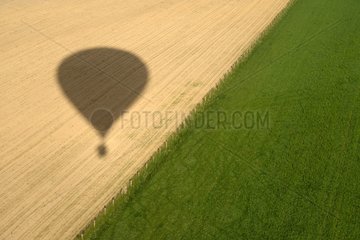 Shadow of a hot air-balloon on a field - France