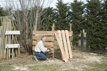 Man building a wooden composting bin Provence