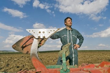 Porträt des Bauern drückte auf seinem Pflug in einem Feld