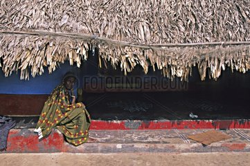 Frau sitzt auf einem Marsch unter einem Dach Indien