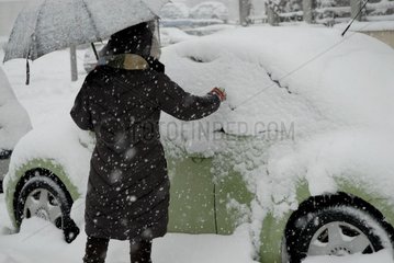 cleaning of a car under snow France downtown