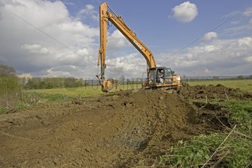 Case mechanical digger excavating new pond Cheltenham UK