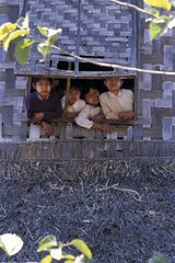 Kinder  die am Fenster eines traditionellen Hauses am Fenster schauen
