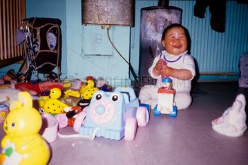 Petite fille Inuit de 1 an au milieu de ses jouets Groenland
