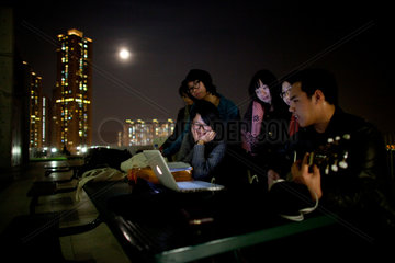Hongkong youth sining on rooftops