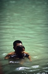 Man and his daughter bathing in a river Thailand