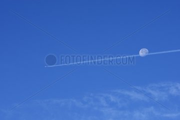 Trace airplane and moon above the Pyrenees Spain