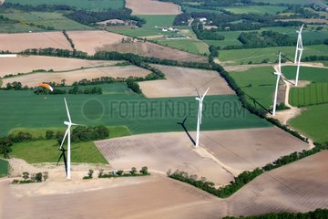 Paramotor flying over a field of windmills Morbihan France