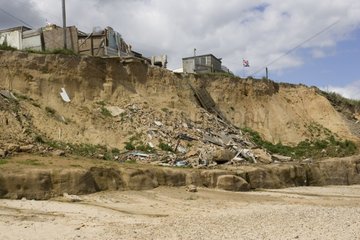 Remains of collapsed houses after severe coastal erosion
