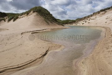Water running between dunes Sutherland Scotland
