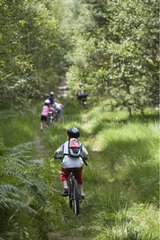 Children riding bikes in Ermenonville forest France