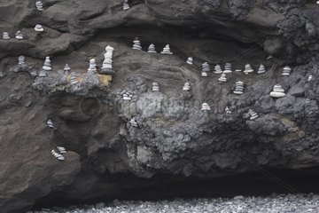 Land Art made with pebbles cairns in a cliff Iceland