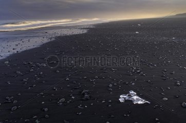 Ice block on black sand beach Joekulsárlón Iceland