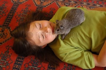 Fillette endormie avec son cochon d'Inde gris