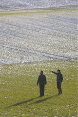 Farmer and technician in a field in winter