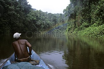 Man on canoe on a river in the rainforest French Guiana