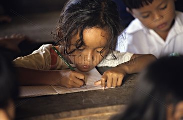 Girl consciously writing on a notebook Cambodia