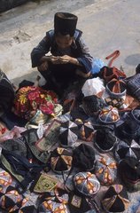 Black H' Mong woman selling bonnets and bags at Sapa market