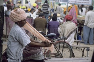 Indien enroulant son turban dans la rue Inde