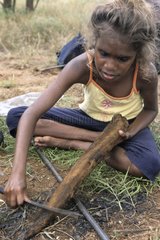 Aboriginal girl cooking a kangaroo tail in Australia