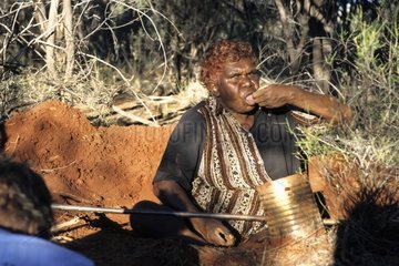 Aboriginal lady eating an honey ant in Australia