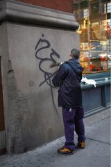 Man erasing graffiti in Soho district New York