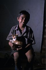 Young boy with a kitten on his knees India