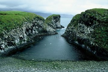 Petite crique entre des falaises basaltiques d'Islande