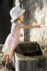 Girl playing with water from a fountain Gourdon Provence