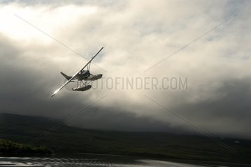Seaplane landing on a lake before a storm sky Katmai