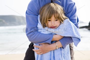 Chilled little girl on a beach with her mother
