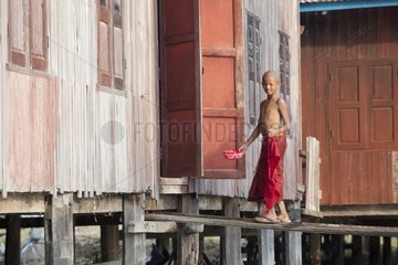 Young monk rinsing his head after shaving Nyaungshwe