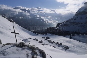 The cross and chalets in the snow Vormy Alps France