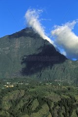 Village and clouds leaned with a rock piton The Reunion