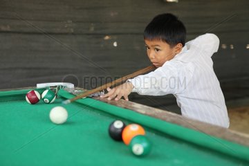 Boy playing pool around Luang Prabang Laos