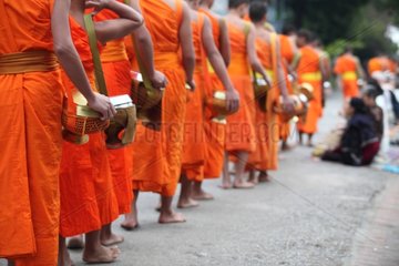Procession of monks in Luang Prabang in Laos at dawn
