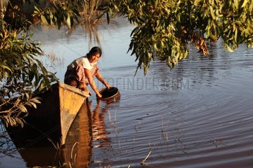 Woman on a boat cleaning a bowl in the Inle lake Burma
