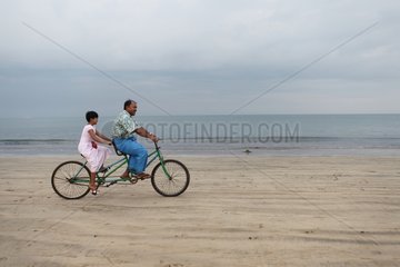 Man doing tandem with his daughter on the beach Burma
