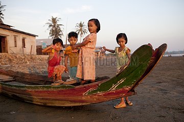 Group of children on a boat at low tide in Burma