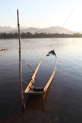 Stranded boat taking water from the Mekong river in Laos
