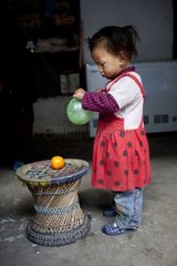Girl playing with a ball outside his home in Nepal