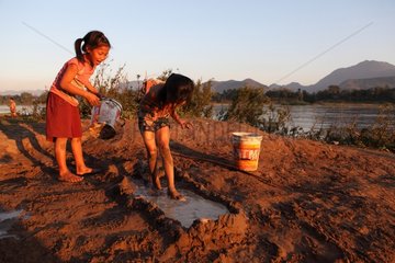 Girls playing in the mud along the Mekong in Laos