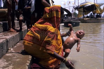 Woman bathing her baby in Gange Varanasi India