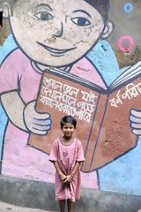 Schoolchild posing in front of a mural in Calcutta India